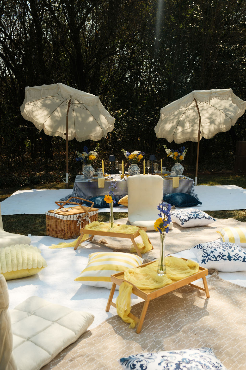 Styled garden picnic with fringed umbrellas and floor cushions