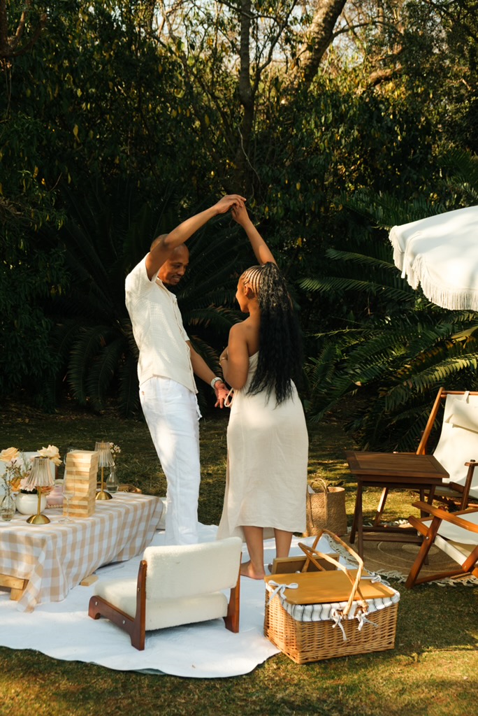 Couple dancing beside their styled picnic setup for two